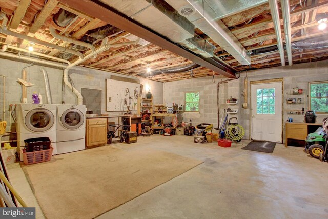below grade area with washing machine and clothes dryer, plenty of natural light, and concrete block wall