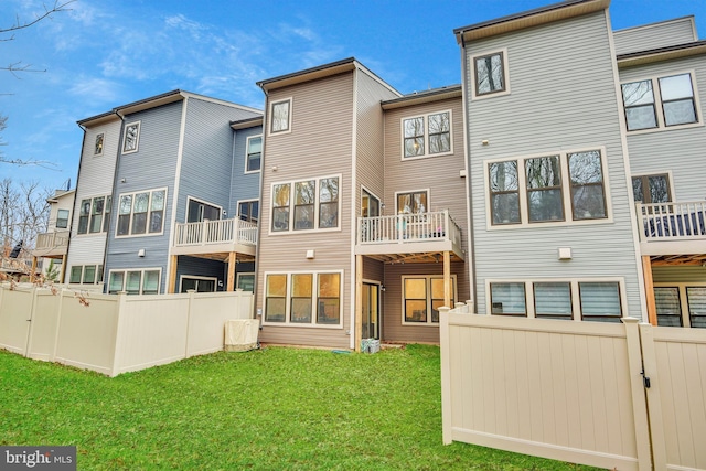 rear view of property with fence and a yard