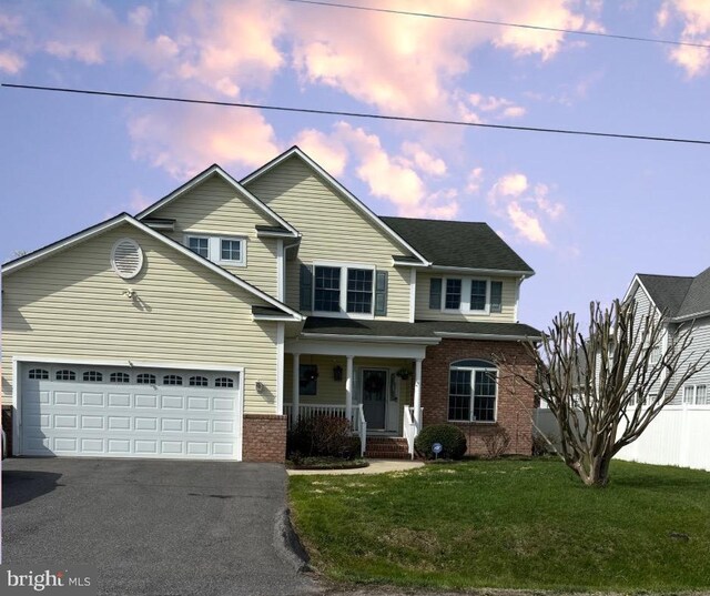 1121 Old Love Point Rd, Stevensville, MD 21666 - traditional home featuring driveway, a porch, fence, brick siding, and an attached garage