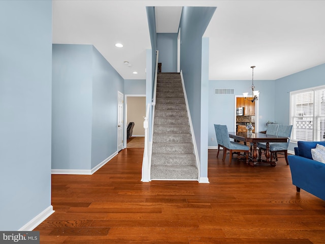 1121 Old Love Point Rd, Stevensville, MD 21666 - stairs with baseboards, wood finished floors, a chandelier, and visible vents