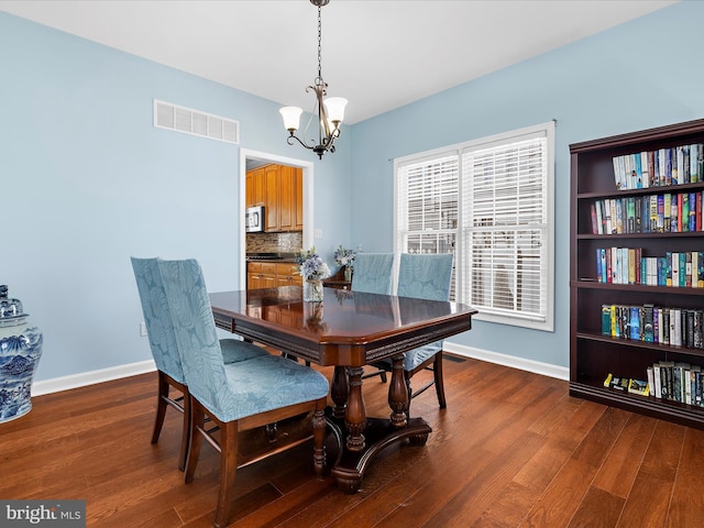1121 Old Love Point Rd, Stevensville, MD 21666 - dining space with wood finished floors, visible vents, baseboards, and an inviting chandelier