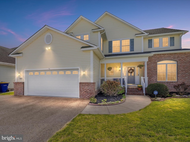 1121 Old Love Point Rd, Stevensville, MD 21666 - traditional home featuring aphalt driveway, covered porch, brick siding, a front yard, and a garage
