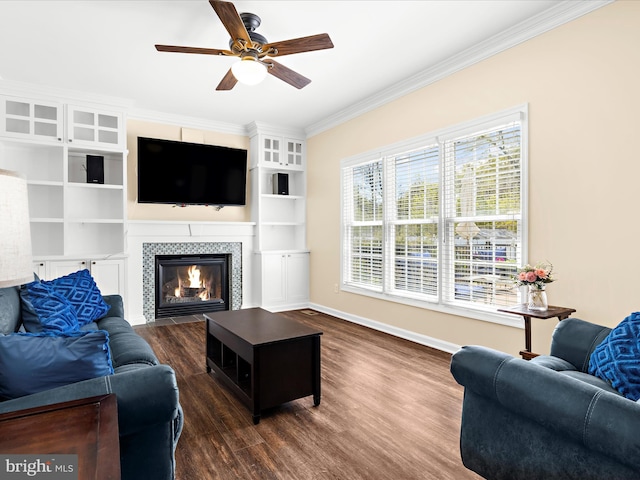 1121 Old Love Point Rd, Stevensville, MD 21666 - living area with crown molding, ceiling fan, a tiled fireplace, dark wood finished floors, and baseboards