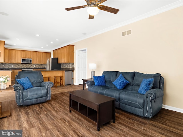 1121 Old Love Point Rd, Stevensville, MD 21666 - living area featuring dark wood-style floors, visible vents, a ceiling fan, ornamental molding, and baseboards