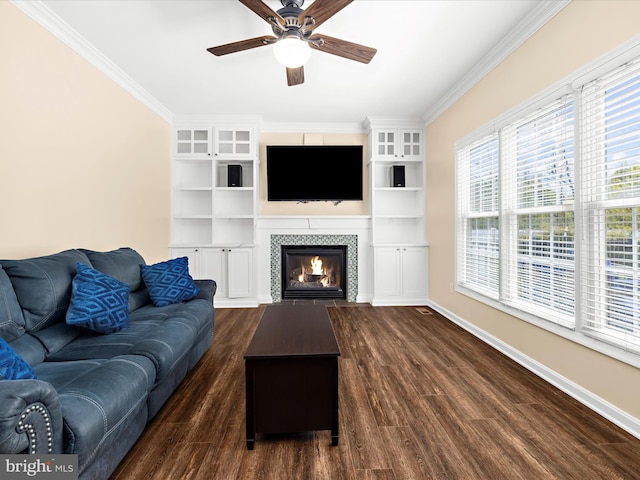 1121 Old Love Point Rd, Stevensville, MD 21666 - living area featuring dark wood-style flooring, ceiling fan, a tiled fireplace, baseboards, and ornamental molding