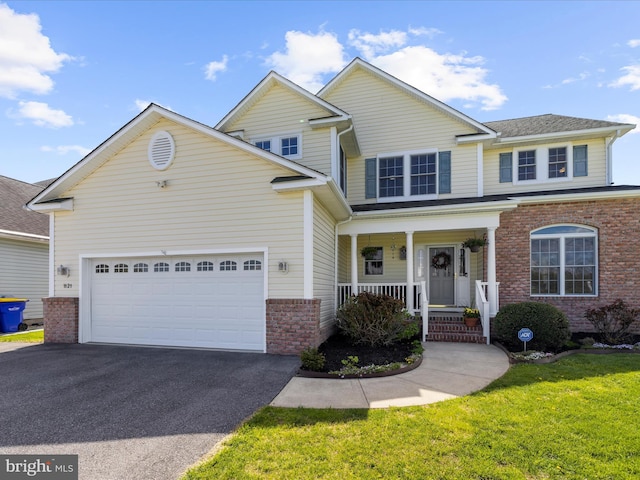 1121 Old Love Point Rd, Stevensville, MD 21666 - view of front of home with a garage, aphalt driveway, a porch, a front yard, and brick siding