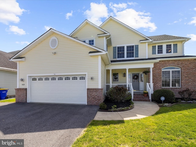1121 Old Love Point Rd, Stevensville, MD 21666 - view of front of home with driveway, covered porch, an attached garage, a front yard, and brick siding