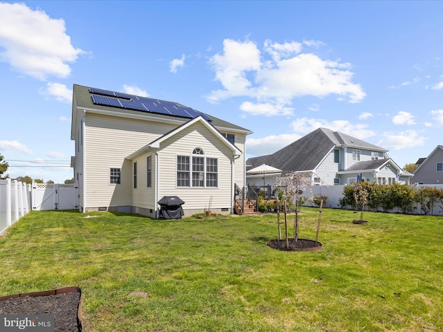 1121 Old Love Point Rd, Stevensville, MD 21666 - back of house with a gate, crawl space, a fenced backyard, roof mounted solar panels, and a yard