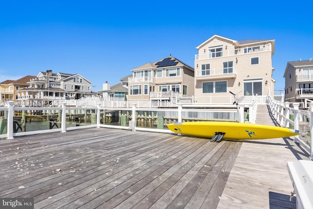 wooden terrace featuring a residential view and a dock