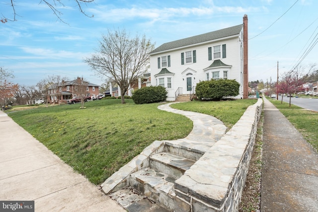 view of front of house featuring a front lawn and a chimney