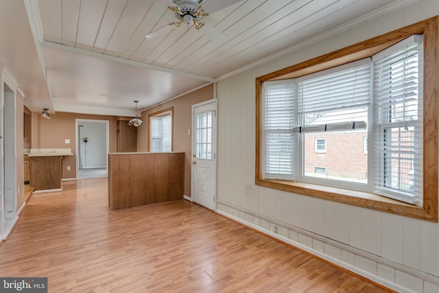 unfurnished living room featuring wooden ceiling, crown molding, a ceiling fan, and light wood finished floors