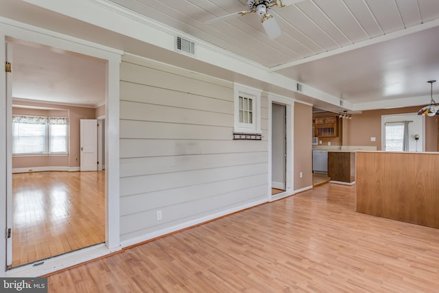 interior space with a wealth of natural light, light wood-type flooring, visible vents, and a ceiling fan