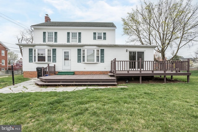 back of property featuring a wooden deck, fence, a yard, and a chimney