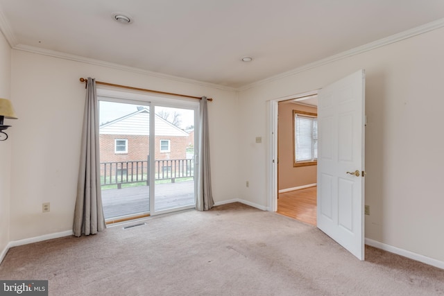 empty room with carpet floors, ornamental molding, plenty of natural light, and baseboards