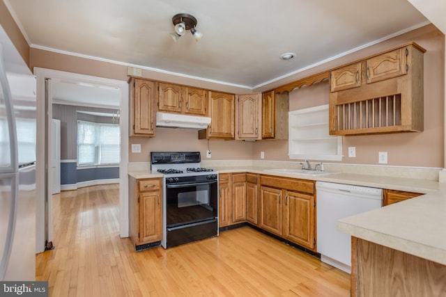 kitchen featuring crown molding, gas range, under cabinet range hood, a sink, and white dishwasher