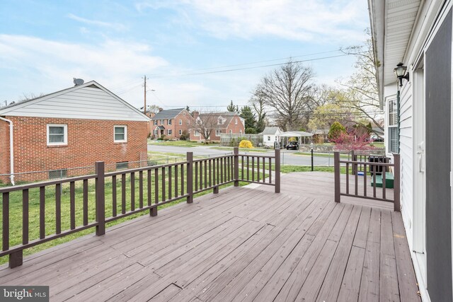 wooden deck featuring a residential view and a lawn
