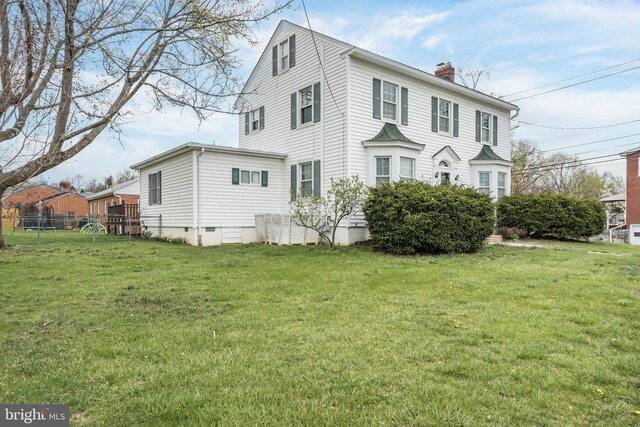 view of front of property featuring a chimney, fence, a front lawn, and crawl space