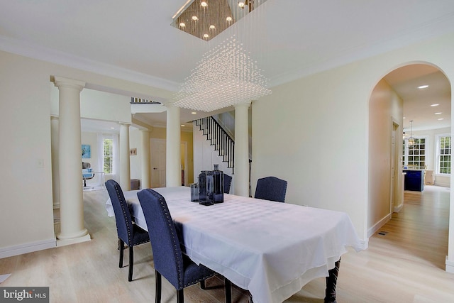 8177 Bodkin Ave, Pasadena, MD 21122 - dining area featuring arched walkways, recessed lighting, baseboards, ornate columns, and light wood-style flooring