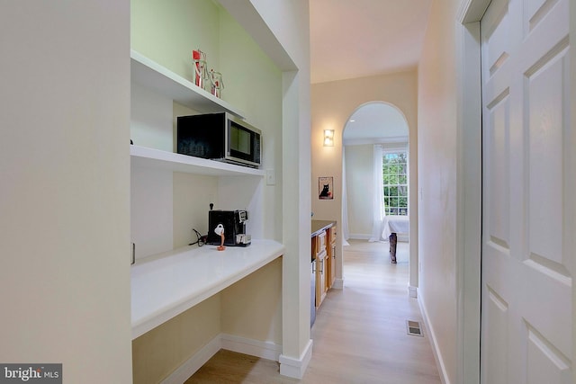 8177 Bodkin Ave, Pasadena, MD 21122 - corridor featuring visible vents, arched walkways, baseboards, and light wood-type flooring