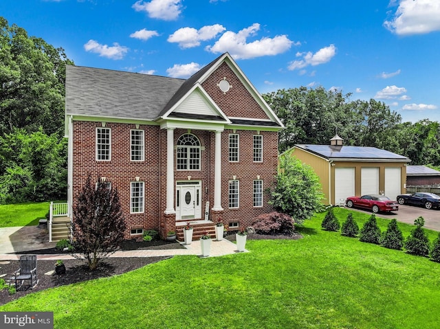 8177 Bodkin Ave, Pasadena, MD 21122 - greek revival house featuring a detached garage, an outdoor structure, brick siding, and a front yard