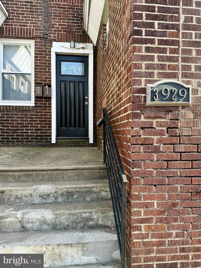 entrance to property featuring brick siding