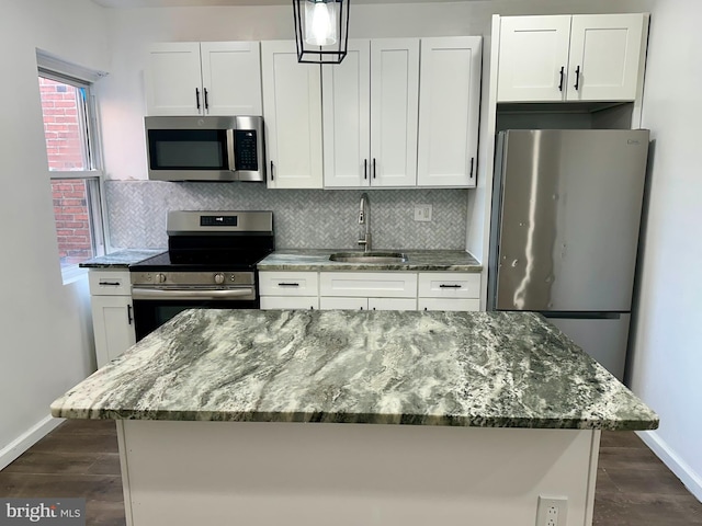 kitchen featuring a sink, appliances with stainless steel finishes, dark wood-style floors, white cabinets, and decorative backsplash
