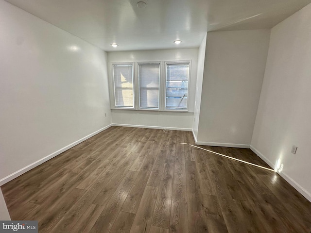 spare room with dark wood finished floors and baseboards