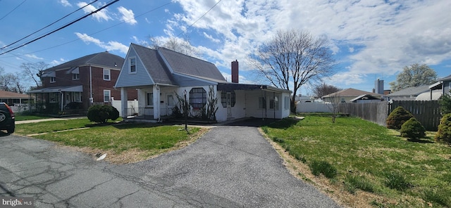 8323 Bear Creek Dr, Baltimore, MD 21222 - view of front of property featuring a chimney, driveway, fence, a porch, and a front yard