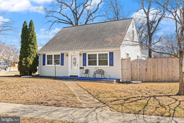 view of front of home featuring a shingled roof and fence
