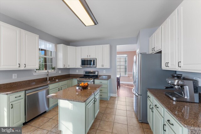 kitchen featuring a center island, appliances with stainless steel finishes, a sink, and plenty of natural light