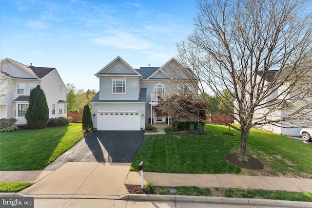traditional-style house featuring a front lawn, aphalt driveway, and an attached garage