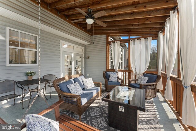 sunroom featuring beamed ceiling, outdoor lounge area, and ceiling fan