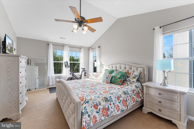 bedroom featuring light colored carpet, lofted ceiling, multiple windows, and visible vents