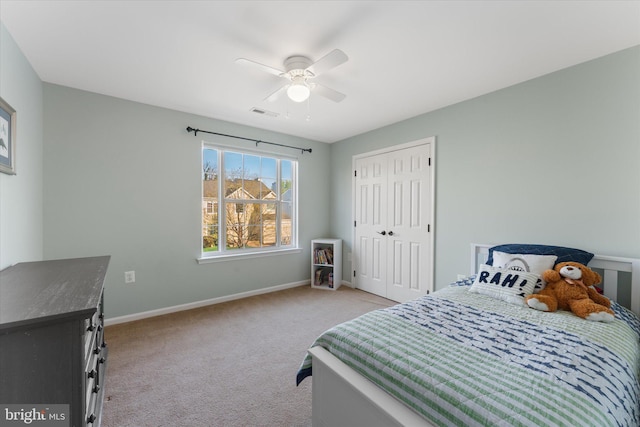 bedroom with visible vents, a ceiling fan, a closet, baseboards, and light colored carpet