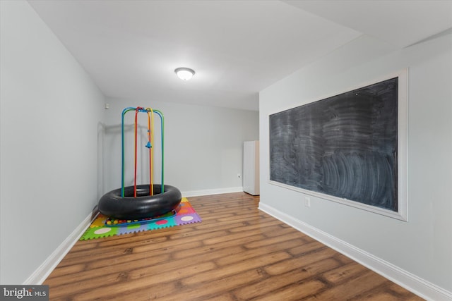 recreation room featuring wood finished floors and baseboards