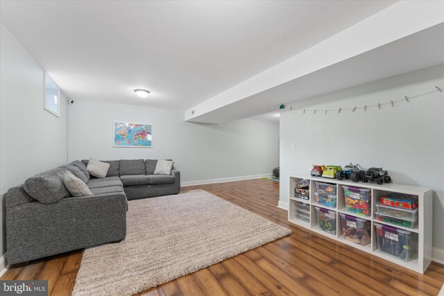 living area with baseboards and wood finished floors