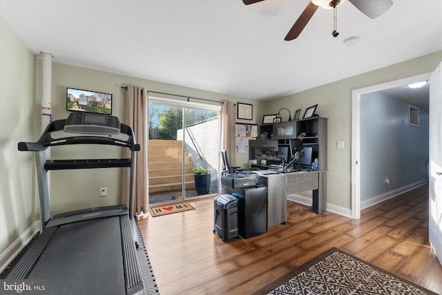 interior space featuring baseboards, a ceiling fan, and wood finished floors