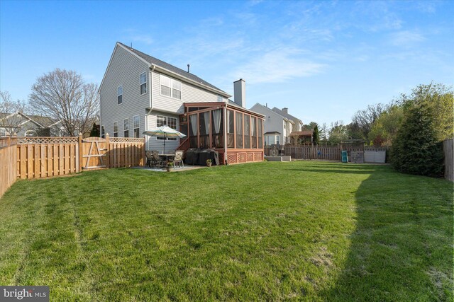 view of yard with a gate, a sunroom, a patio, and a fenced backyard