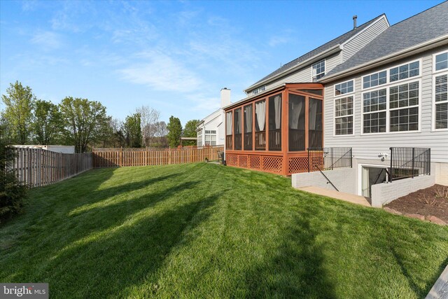view of yard with a fenced backyard and a sunroom