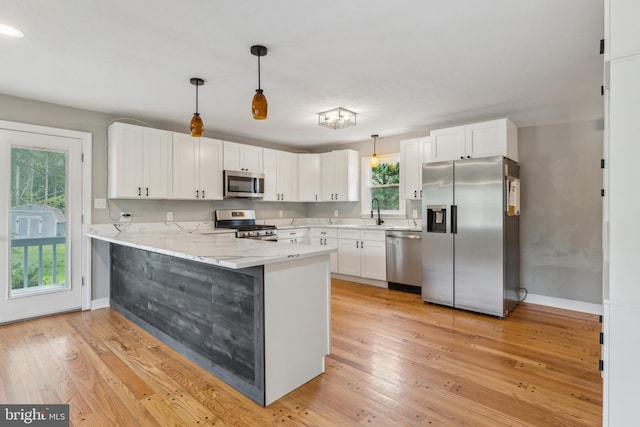 19316 Landora Bridge Rd, Ruther Glen, VA 22546 - kitchen featuring appliances with stainless steel finishes, a peninsula, white cabinetry, baseboards, and light wood-style flooring