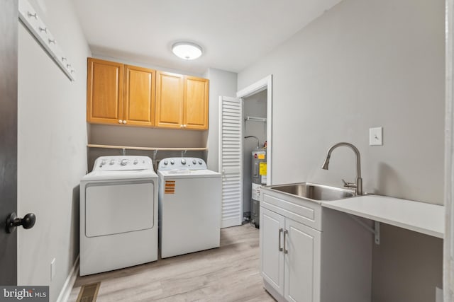 19316 Landora Bridge Rd, Ruther Glen, VA 22546 - washroom featuring washing machine and dryer, electric water heater, cabinet space, and light wood-type flooring