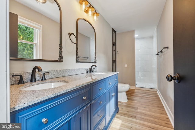 19316 Landora Bridge Rd, Ruther Glen, VA 22546 - full bath with double vanity, toilet, wood finished floors, a tile shower, and baseboards
