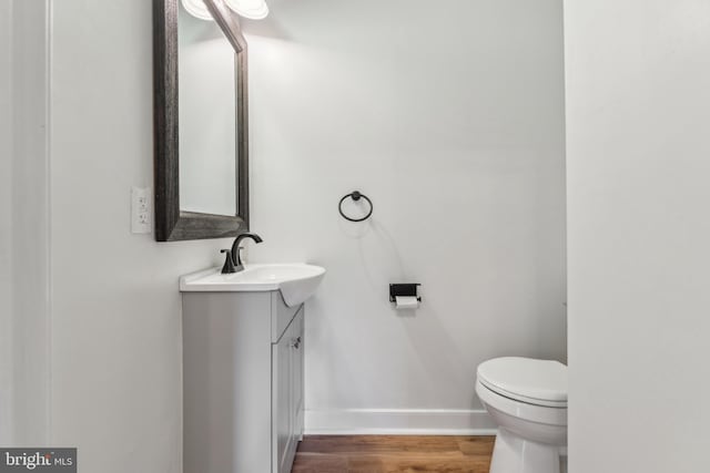 19316 Landora Bridge Rd, Ruther Glen, VA 22546 - half bathroom featuring vanity, baseboards, wood finished floors, and toilet