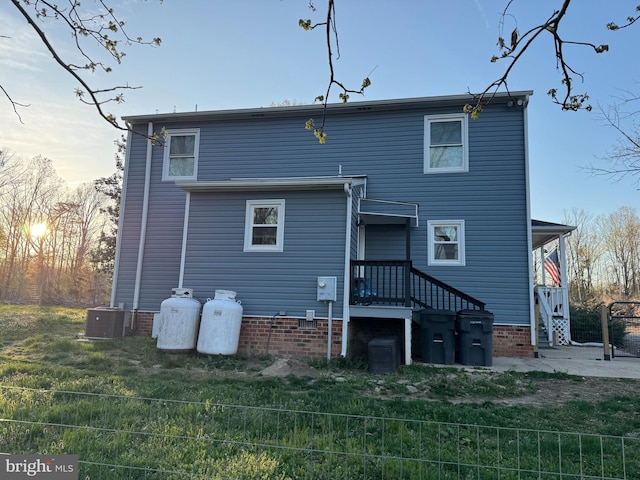 back of house with a lawn, fence, and cooling unit
