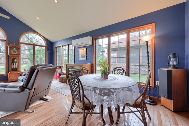 3902 Reiff Pl, Reading, PA 19606 - dining space featuring a fireplace, light wood finished floors, an AC wall unit, and vaulted ceiling