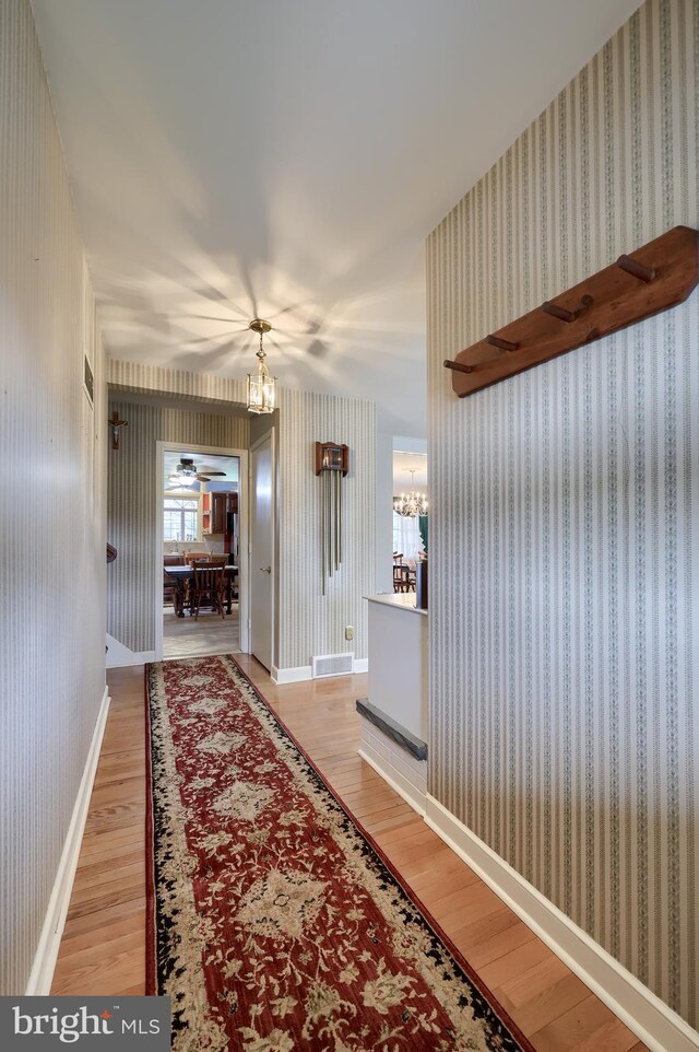 3902 Reiff Pl, Reading, PA 19606 - corridor with visible vents, a chandelier, baseboards, wallpapered walls, and wood finished floors
