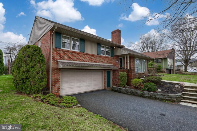 3902 Reiff Pl, Reading, PA 19606 - split level home featuring brick siding, driveway, a garage, and a chimney
