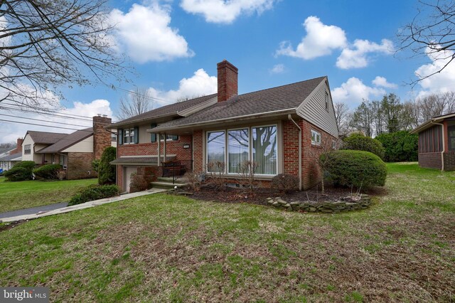 3902 Reiff Pl, Reading, PA 19606 - back of house with roof with shingles, a chimney, an attached garage, brick siding, and a yard