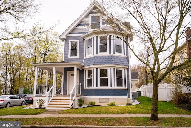 201 Morrison Ave, Hightstown, NJ 08520 - victorian house with fence, a front lawn, a porch, and central AC unit