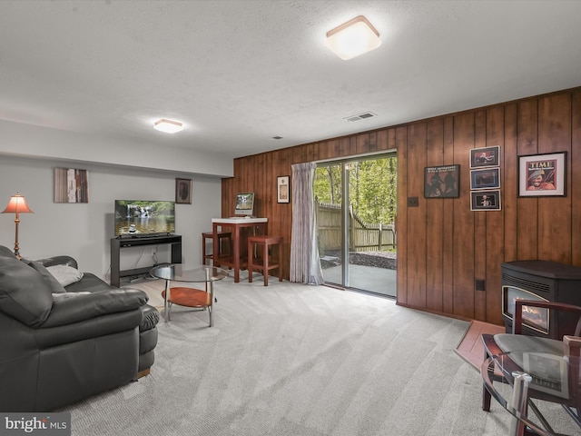 30 Drawbridge Ct, Baltimore, MD 21228 - living area featuring a textured ceiling, visible vents, a wood stove, wooden walls, and carpet